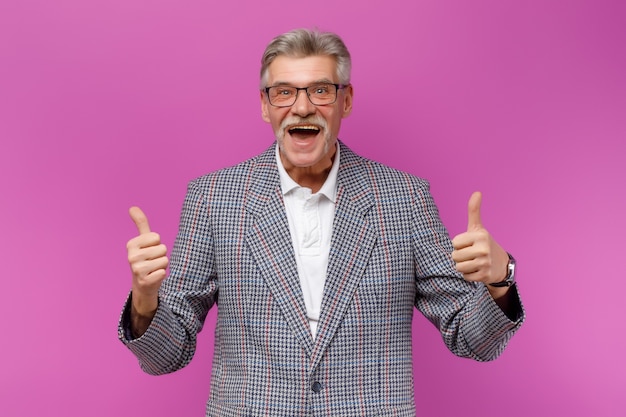 Emotional handsome mature man wearing jacket looking at front with okay single gesture against violet wall