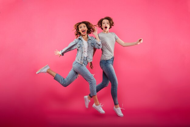 Emotional ladies friends jumping isolated