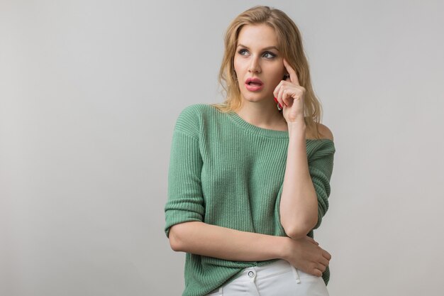 Emotional portrait of young attractive woman thinkig, idea, holding finger at her head, having proble, frustrated, casual style, green sweater, crossed arms, isolated, looking up