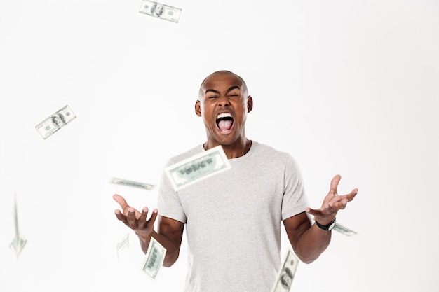 Free photo emotional screaming young african man with money.