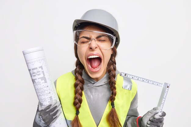 Free photo emotional woman engineer exclaims loudly keeps mouth opened