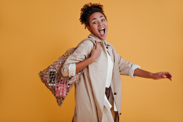 Emotional woman posing with string bag