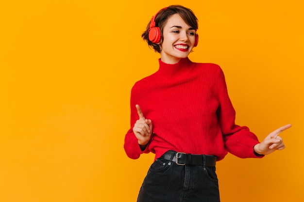 Emotional woman in red sweater dancing with smile