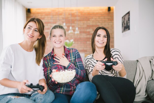 Emotional women playing game and having popcorn