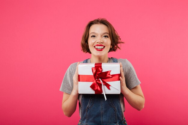 ギフト用の箱を保持している感情的な若い女性。