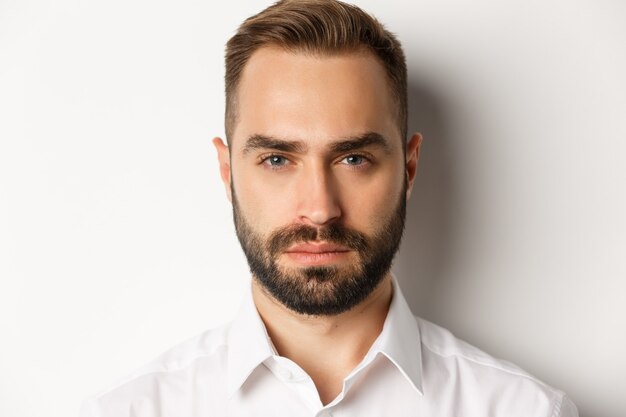 Emotions and people concept. Headshot of serious-looking handsome man with beard, looking confident and determined 