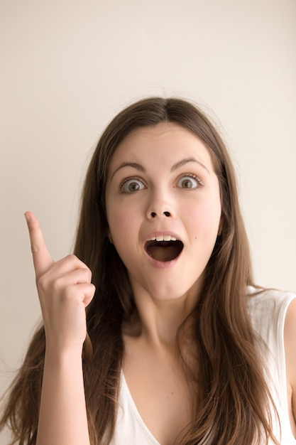 Emotive headshot portrait of amazed young woman