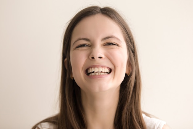 Emotive headshot portrait of laughing young woman