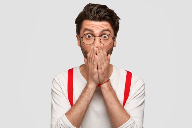 感情的な男は恐怖で口を覆い、恐怖で叫び、何か怖いものを見る