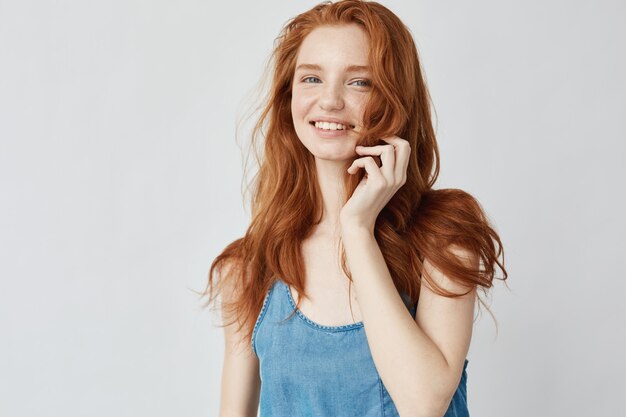Эмоциональная искренняя счастливая девушка с рыжими волосами улыбается.