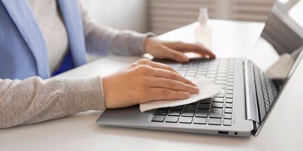 Employee disinfecting electronic device