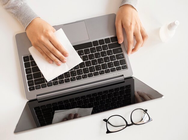 Employee disinfecting electronic device