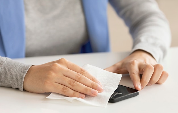 Free photo employee disinfecting electronic device