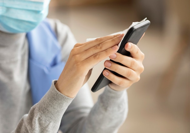 Employee disinfecting electronic device