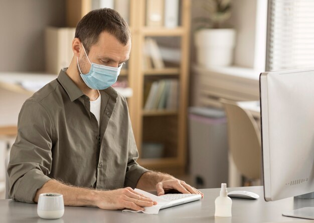 Employee disinfecting electronic device