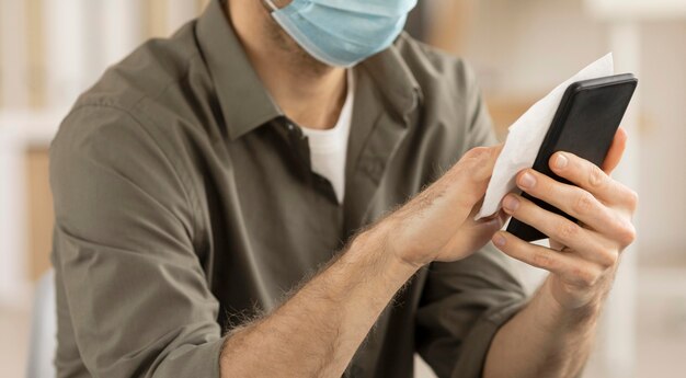 Employee disinfecting electronic device