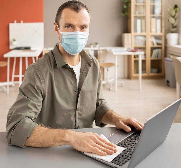 Employee disinfecting electronic device