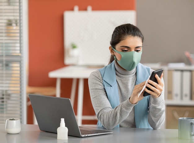 Free photo employee disinfecting electronic device