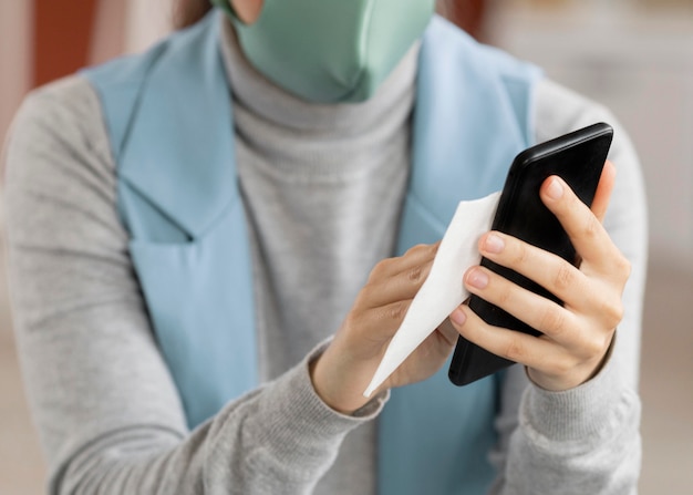 Employee disinfecting electronic device