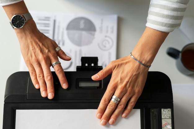 Dipendente che utilizza la stampante al lavoro vista dall'alto