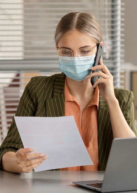 Free photo employee wearing face mask at the office