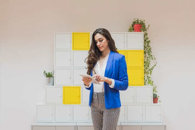 Employee with blue jacket using her tablet