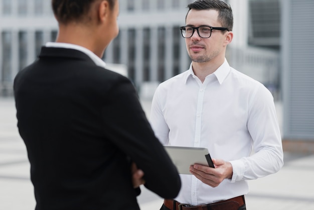 Employee with glasses looking at colleague