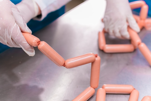 Employees sorting produced sausage products