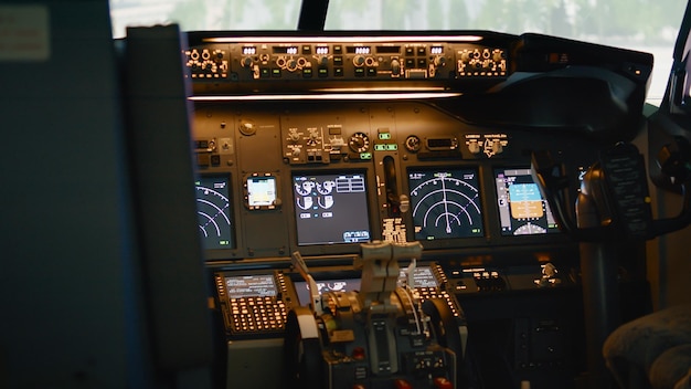 Free photo empty airplane cockpit with dashboard and control panel command, electronic aircraft radar. no people in plane cabin with navigation, lever, switch and compass to takeoff. handheld shot.