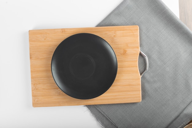 An empty black ceramic saucer