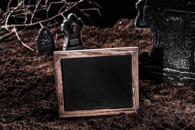 Empty blackboard on Halloween graveyard