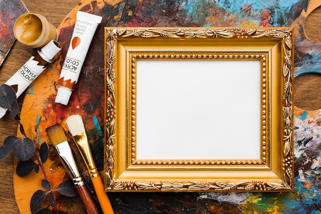 Empty canvas in golden frame and paint