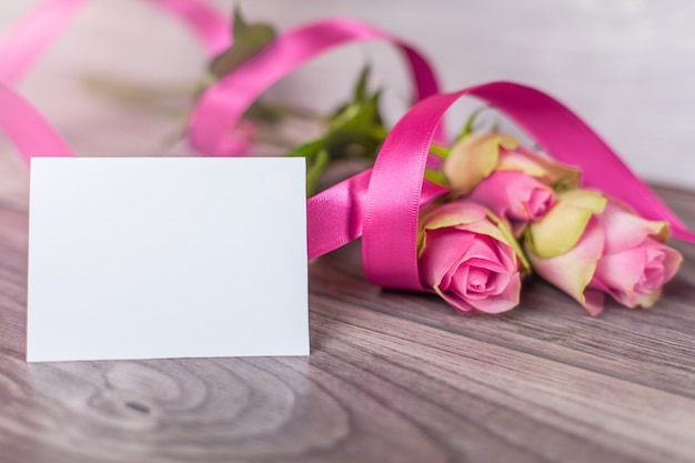 Empty card with roses on wood
