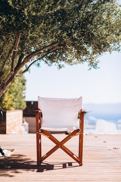 Empty chair under the palm at the beach