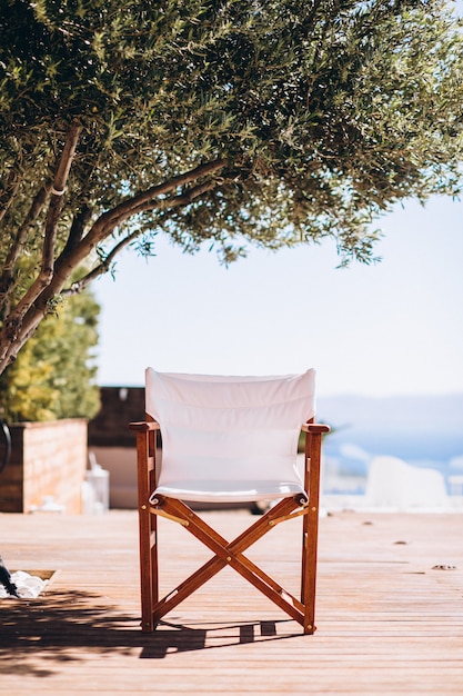 Empty chair under the palm at the beach