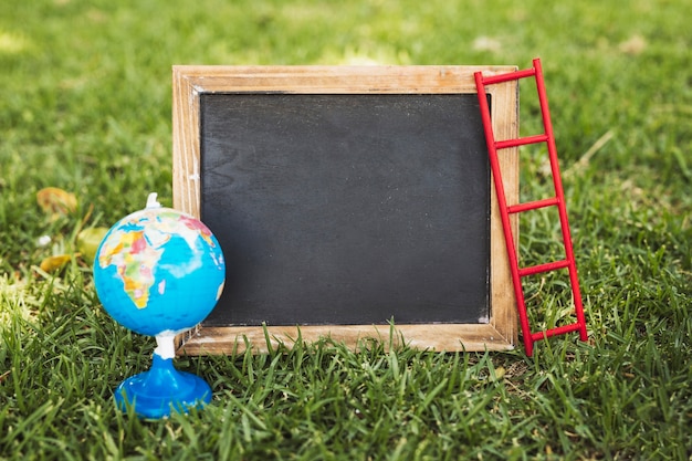 Free photo empty chalkboard and globe on nature