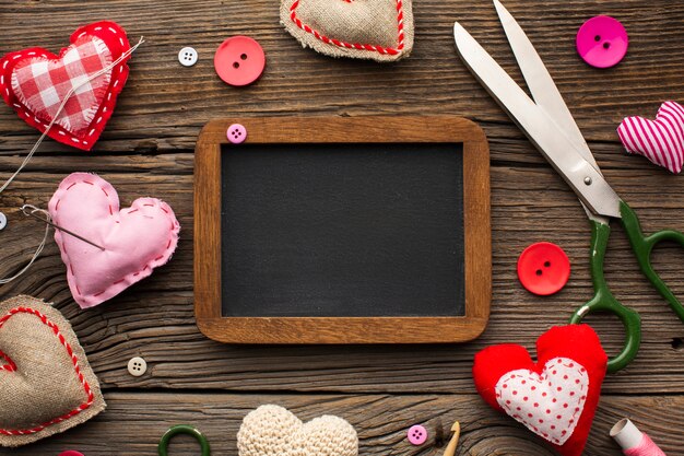 Empty chalkboard surrounded by haberdashery accessories