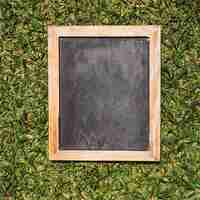 Free photo empty chalkboard with wooden frames on green background