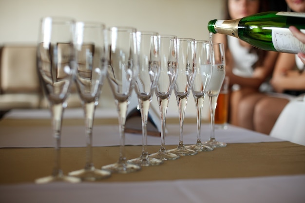 Empty champagne flutes stand in a ray on the dinner table