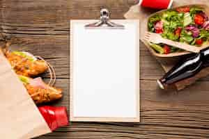 Free photo empty clipboard with fast food and soda