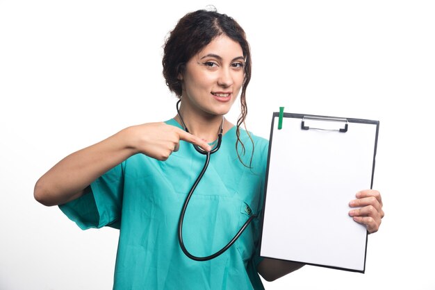 Empty clipboard with pen in hands of female doctor on white background . High quality photo