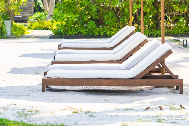레저 휴가를위한 호텔 리조트의 야외 수영장 주변에 빈 갑판 의자