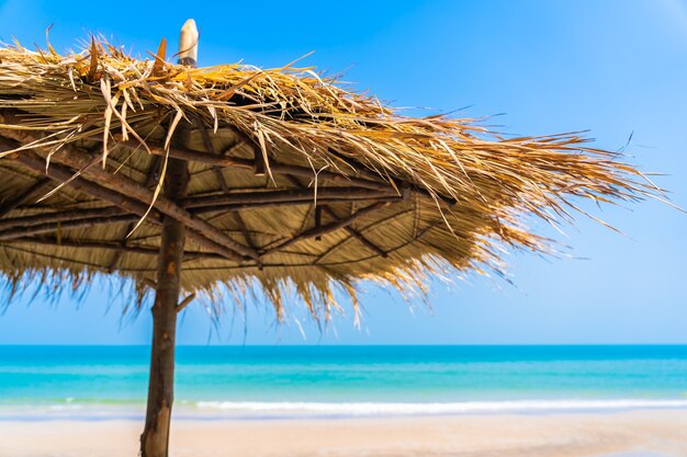 Empty deck chair lounge with umbrella around on beach sea ocean blue sky for leisure travel vacation