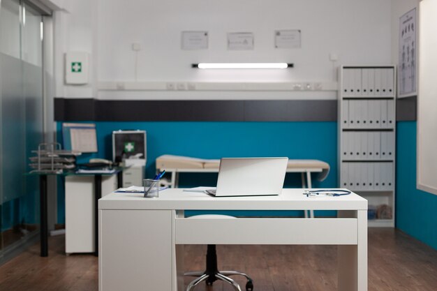 Empty doctors workplace room with desk and technology