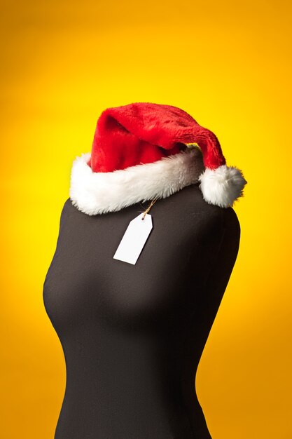 empty dummy with Santa hat, sale price tag hanging from  button hole. shopping and sale concept