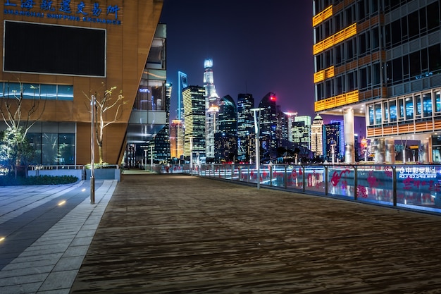 Empty floor with modern skyline and buildings at night in Shanghai