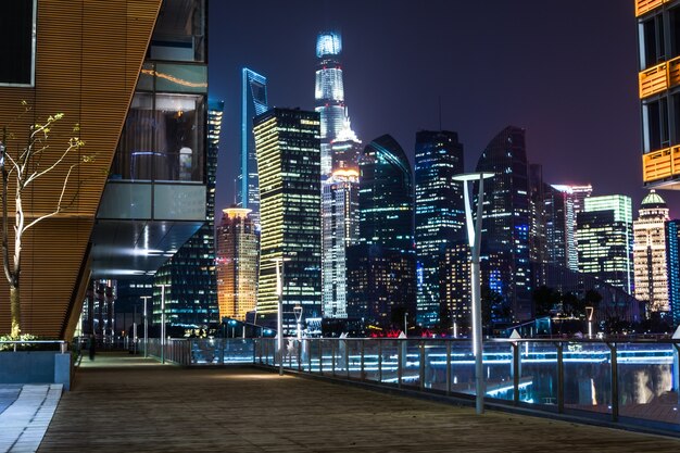 Empty floor with modern skyline and buildings at night in Shanghai