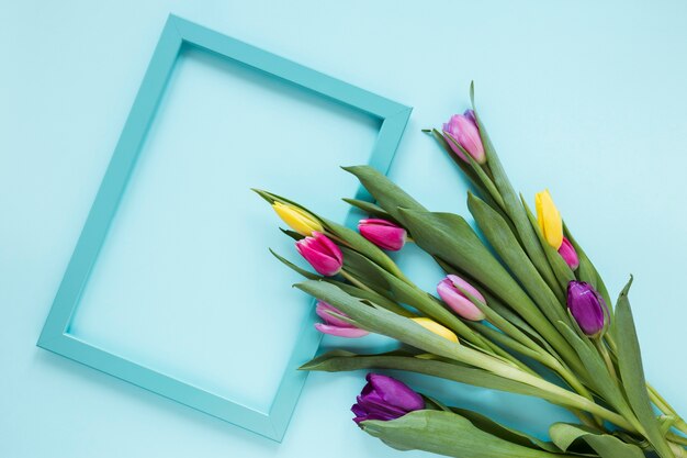 Empty frame and bouquet of colourful tulip flowers