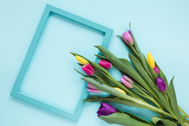 Empty frame and bouquet of colourful tulip flowers