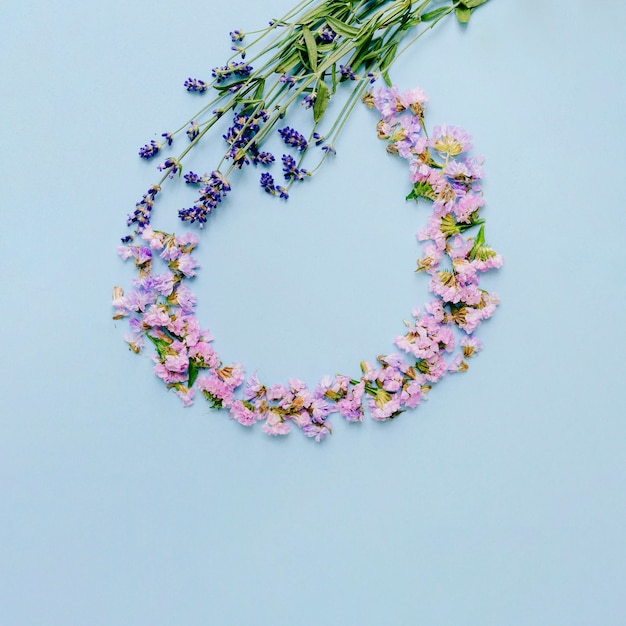 Empty frame made with flowers on blue background